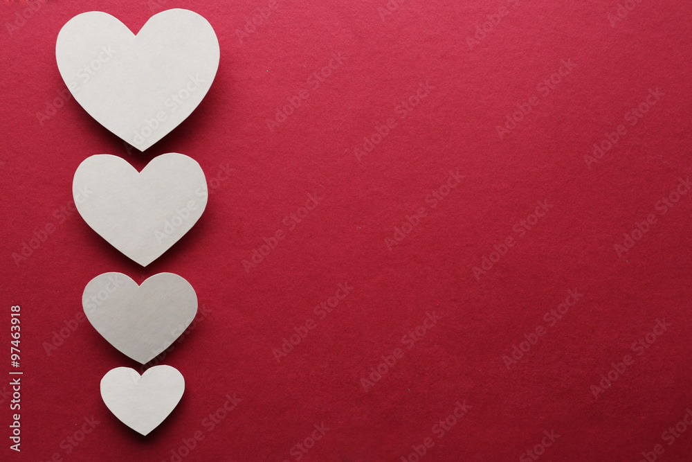 White paper hearts on dark pink background