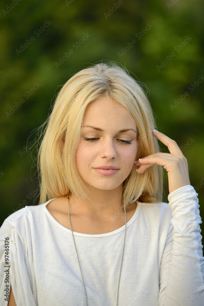 Portrait of beautiful blond girl with green background