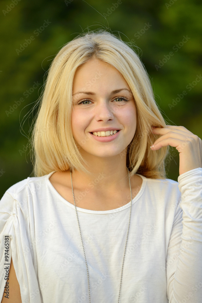 Portrait of beautiful blond girl with green background