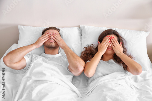 Happy couple snoozing on bed photo