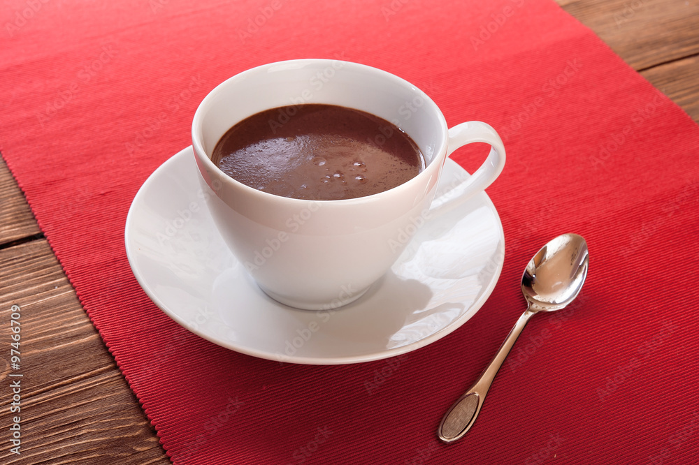 Obraz premium Hot chocolate in a white cup on a wooden table