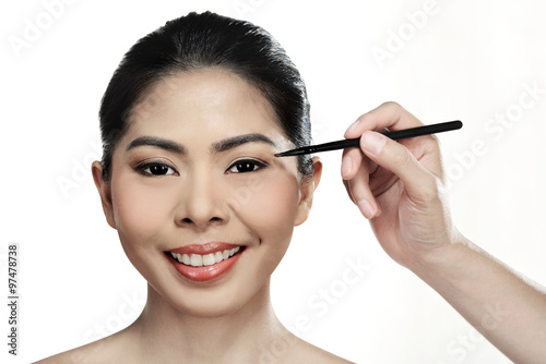 Beautiful asian woman doing makeup