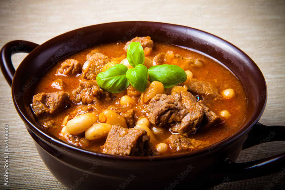 Traditional turkish meal - Kuru fasulye in a clay bowl on a ligh Traditional turkish meal - Kuru fasulye in a clay bowl on a ligh