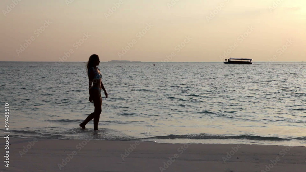 Silhouette of woman against a sunset at ocean Silhouette of woman against a sunset at ocean