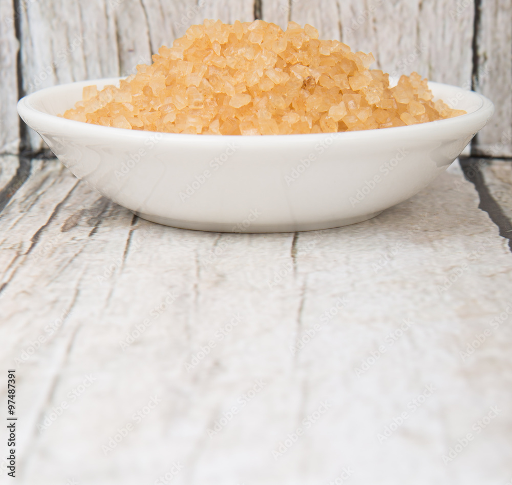 Brown sugar in white bowl over wooden background Brown sugar in white bowl over wooden background
