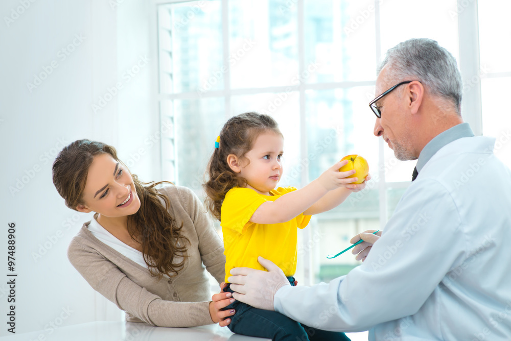 Obraz premium Aged doctor with little patient in hospital office