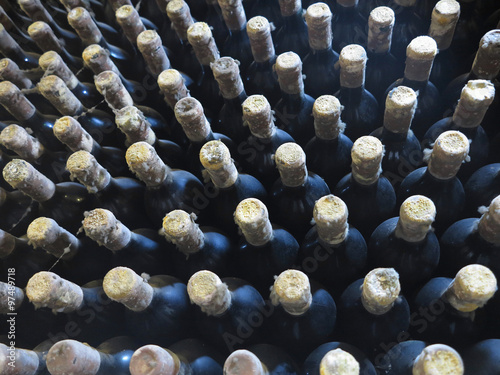 Old dirty wine bottles stacked up in cellar