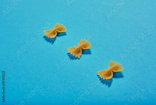 Three farfale pasta pieces on blue background