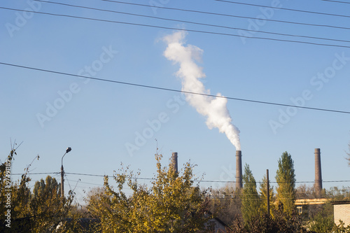 Industrial landscape with smoking chimneys power station. Three chimneys.