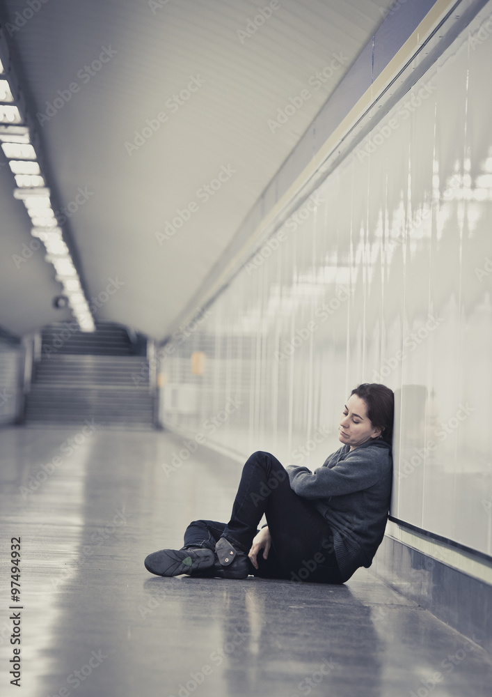 young sad woman in pain alone and depressed at urban subway tunnel ground worried suffering depression young sad woman in pain alone and depressed at urban subway tunnel ground worried suffering depression