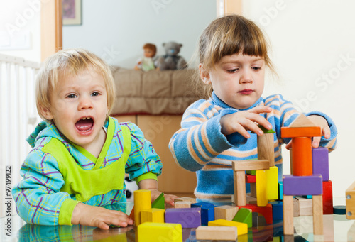   siblings playing with wooden toys