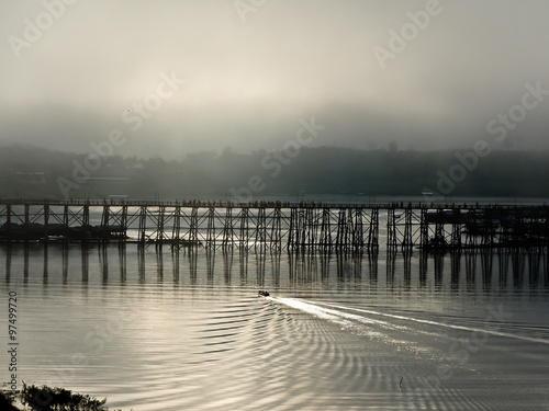 silhouette wood bridge in sunrise with morning mist