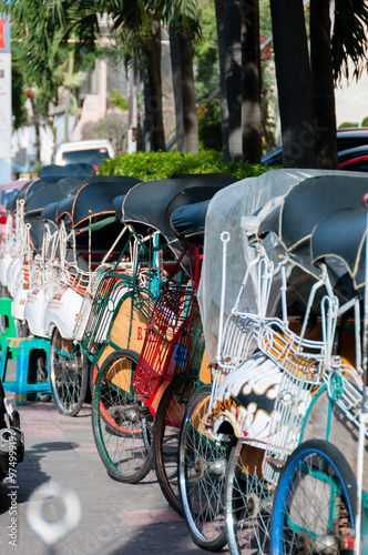 Array of Tricycle and Bicycle on the street in a City in Indonesia photo