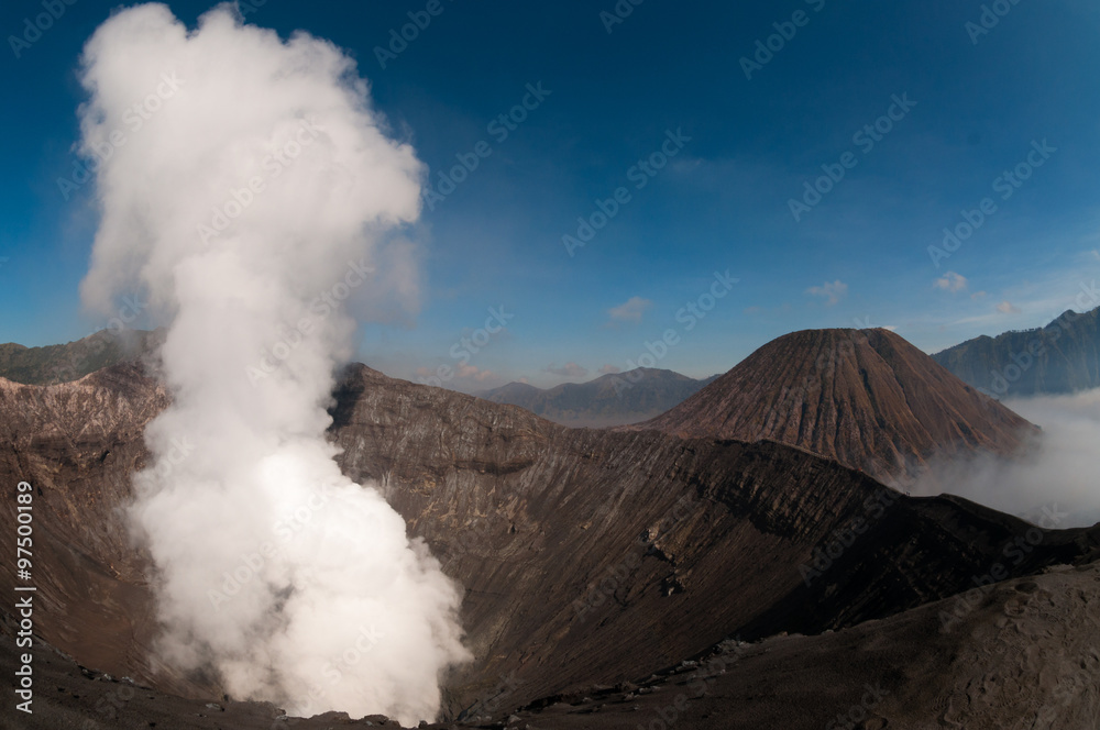 Volcano Bromo Errupting Smoke and sulfur under blue sky