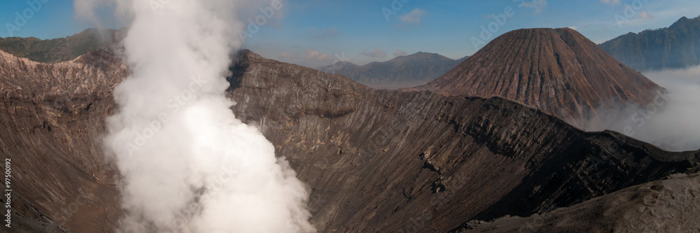 Volcano Bromo Errupting Smoke and sulfur under blue sky