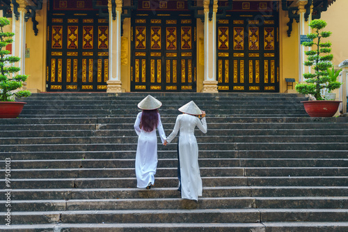 A Vietnamese girls wearing conical hat and Ao Dai (Vietnamese traditional costume or Long Dress) at Saigon Zoo, Ho Chi Minh city, Vietnam