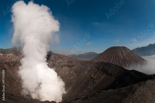 Volcano Bromo Errupting Smoke and sulfur under blue sky