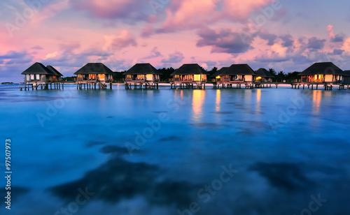Water bungalows with beautiful twilight sky and sea in Maldives. Long Exposure.