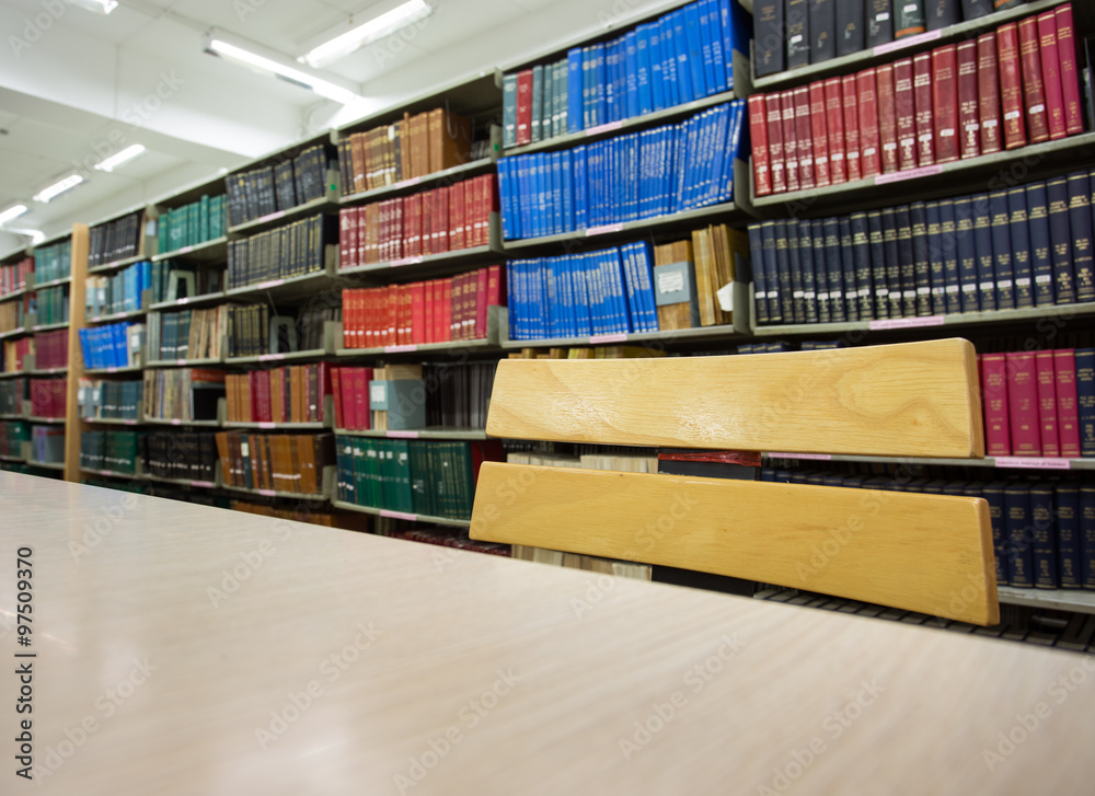 Obraz premium book on desk in library with book column background