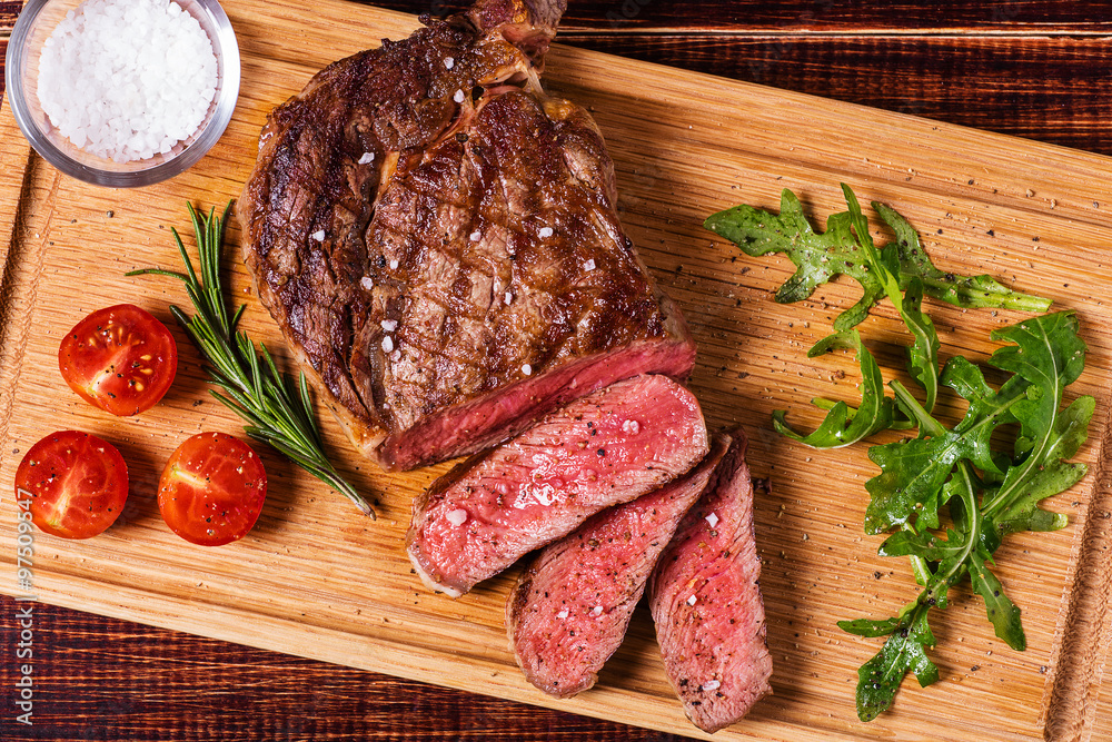 Ribeye steak with arugula and tomatoes. Ribeye steak with arugula and tomatoes.