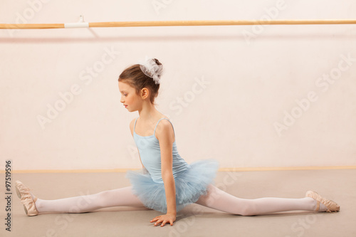 Little ballerina girl posing in ballet studio