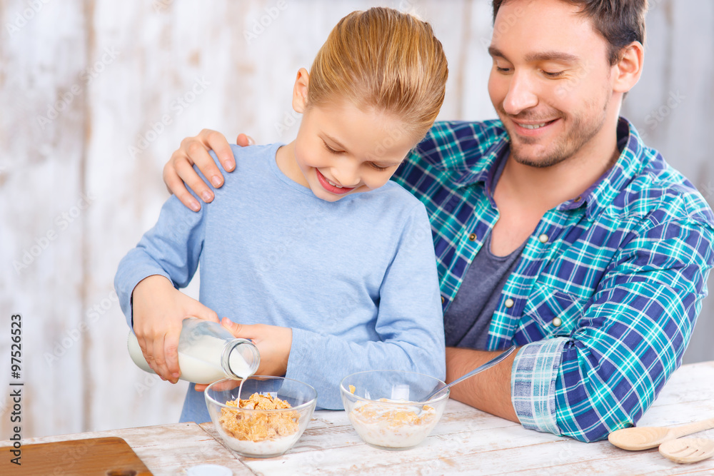Positive father and daughter having breakfast Positive father and daughter having breakfast