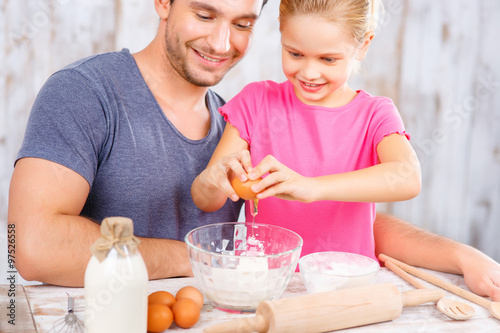 Happy father and daughter baking together 