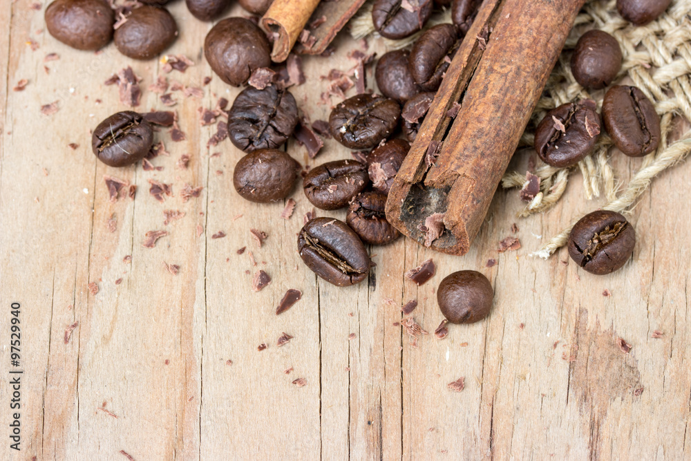 Obraz premium chocolate, cinamon and coffee beans on wooden table.