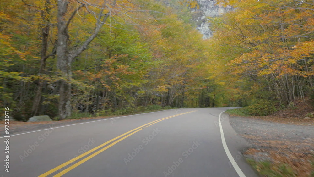 Driving POV on Vermont State Route 108 through Smugglers Notch in autumn.