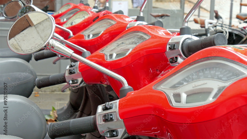 The dashboard of the red scooters parked on the street of Paris with the side mirrors The dashboard of the red scooters parked on the street of Paris with the side mirrors