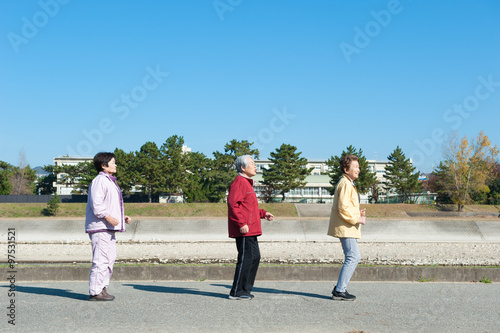 一列になって歩いている3人のアジア人高齢者