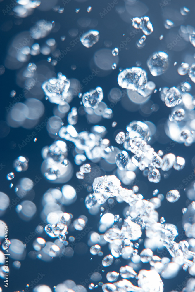 Water drops levitate in the air on dark blue background