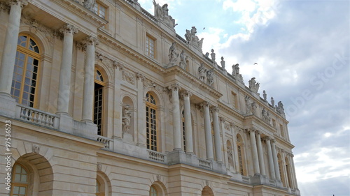 Outside view of the Versaille castle in France in daytime. There are some statues and sculptures on the castles acrhitecture