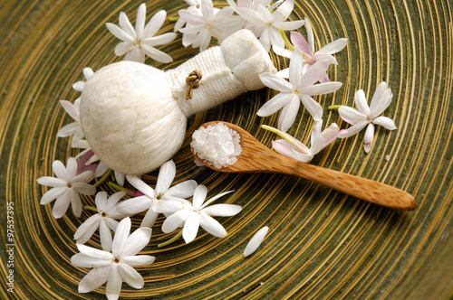 White flower with ball, salt in spoon in wooden bowl 
