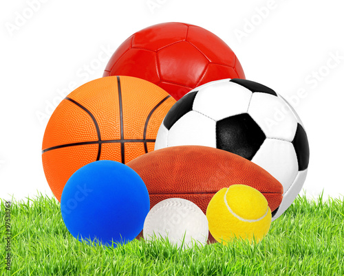 Sports balls on green grass isolated on white