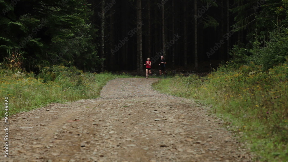 Couple Running on a Gravel Road in Forest Couple Running on a Gravel Road in Forest