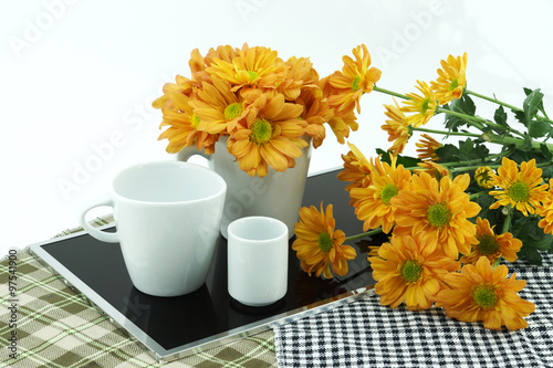 orange chrysanthemum and coffee cup