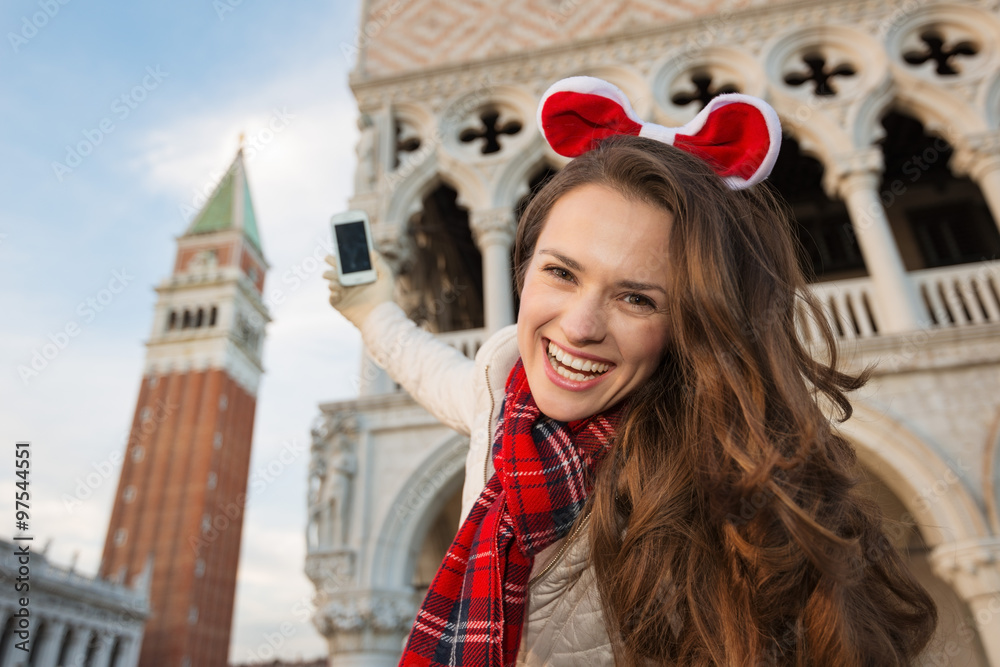 Fototapeta premium Woman tourist taking photos while on Christmas in Venice, Italy