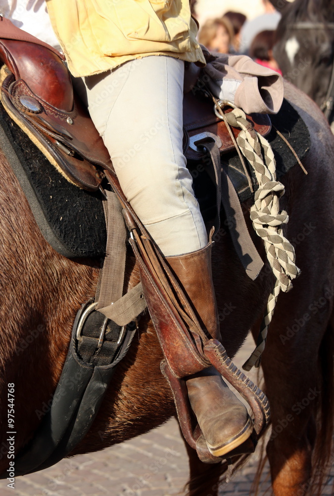 Cowboy boot in the stirrup of the horse during the ride