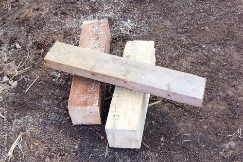 Obraz na plátne two wooden beams and board trim on bare ground
