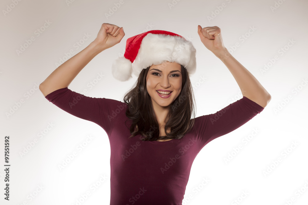 a young beautiful woman posing with Santa Claus cap a young beautiful woman posing with Santa Claus cap