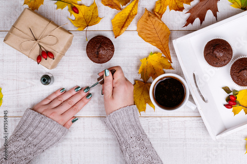 Woman having manicure on a wooden rustic table
