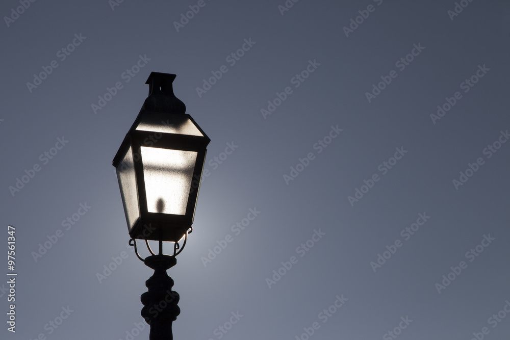 Old street lamp on a background of dramatic dark blue skyBacklight. Highlights sun. Space for text