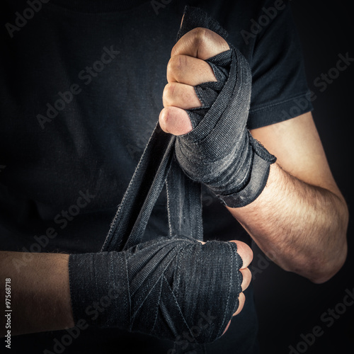 Billede på lærred Boxer pulls boxing bandages on his hands