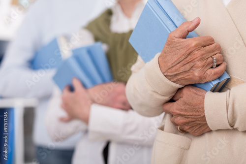 Senior people holding books