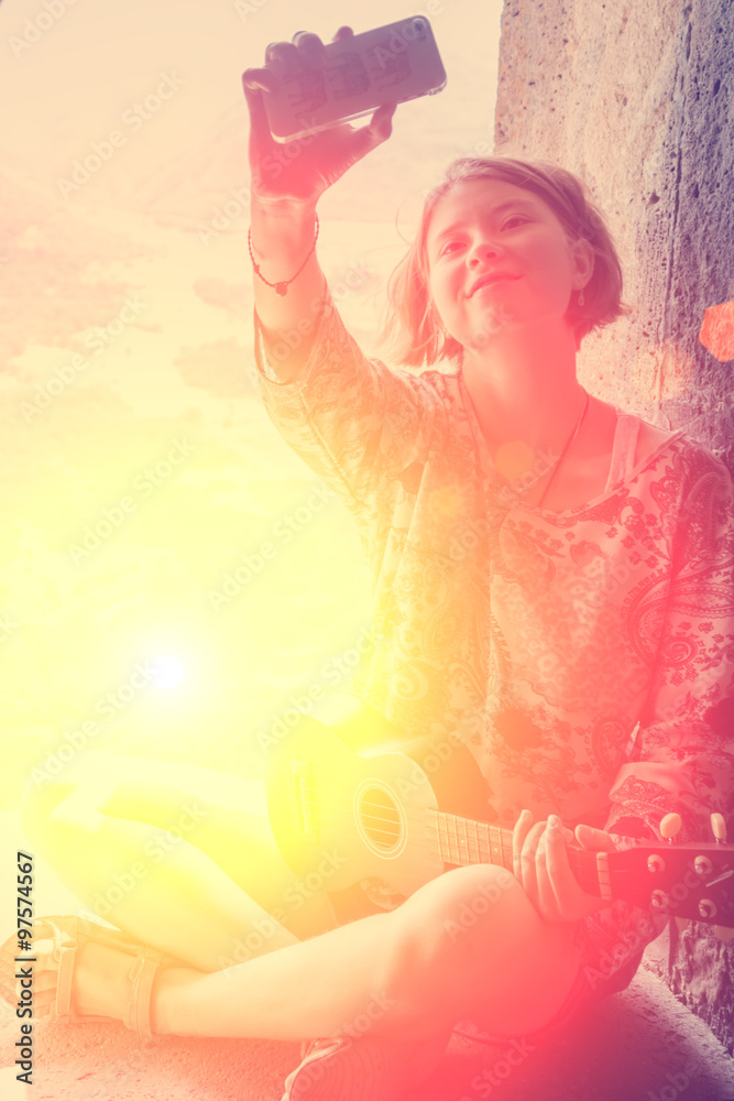 Young girl with ukulele sitting in arched window and taking photo selfie Young girl with ukulele sitting in arched window and taking photo selfie
