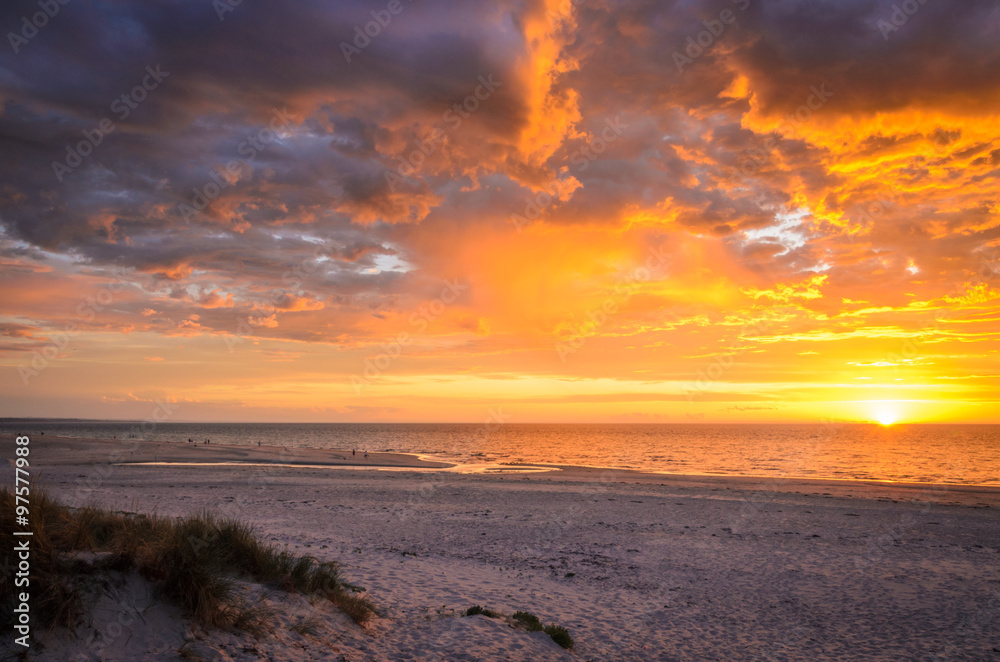 Fototapeta premium Dramatic sunset at the beach through dunes