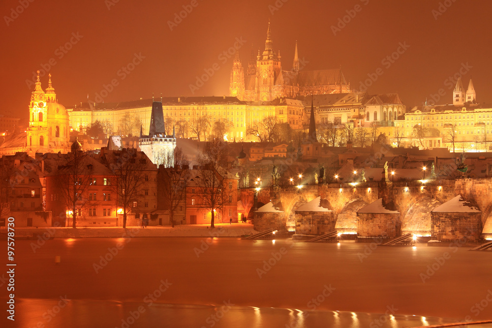 Night snovy christmas Prague gothic Castle and St. Nicholas' Cathedral with Charles Bridge, Czech republic