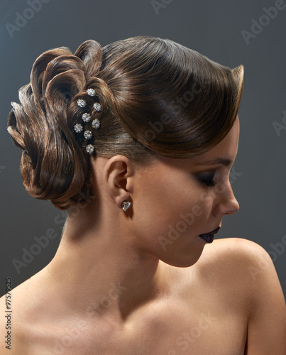 Young beautiful woman with fashion hairstyle posing in the studio