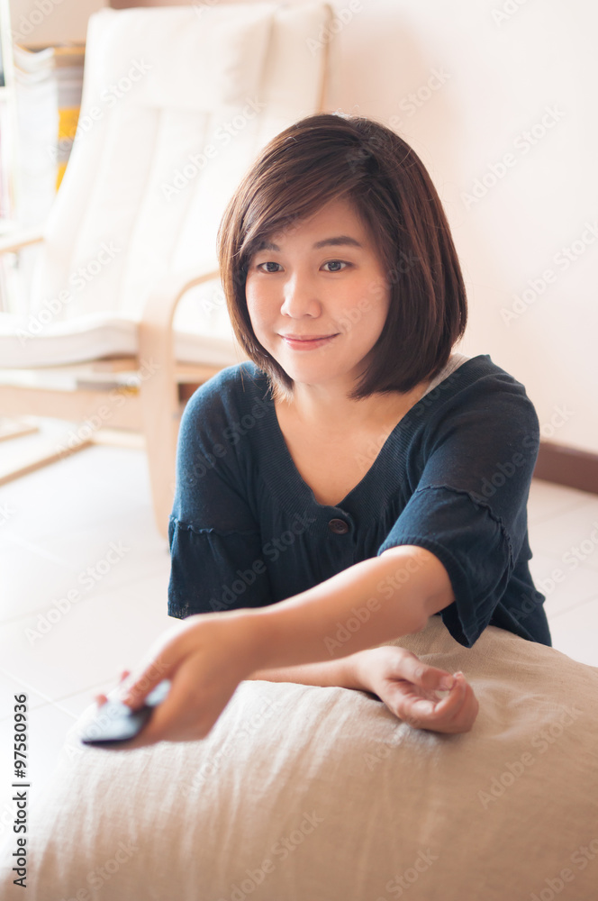 Woman holding remote control with smiling face. Woman holding remote control with smiling face.